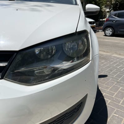 חזית רכב לבן עם פנס קדמי ושבכה