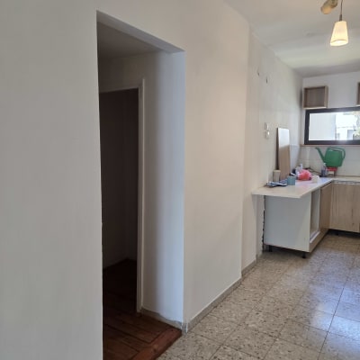 מטבח נקי עם רצפה מבריקה וחפצים מסודרים על השיש