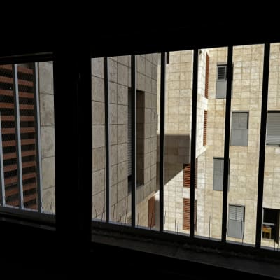 סורגים על חלון עם מבנה אבן ברקע