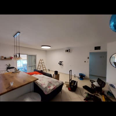 סולם עומד ליד קיר גבס בחדר עם כלים שונים