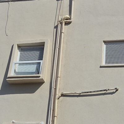 צנרת חיצונית על קיר בניין עם חלונות