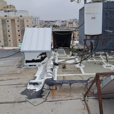 גג עם צלחות לוויין, צינורות ואיטום לבן