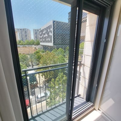 רשת נגד יונים מותקנת על חלון מרפסת