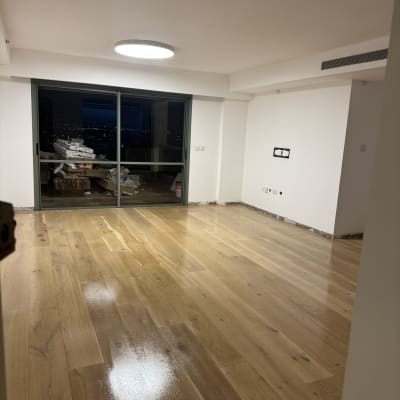 רצפת פרקט חדשה בחדר ריק עם חלון גדול