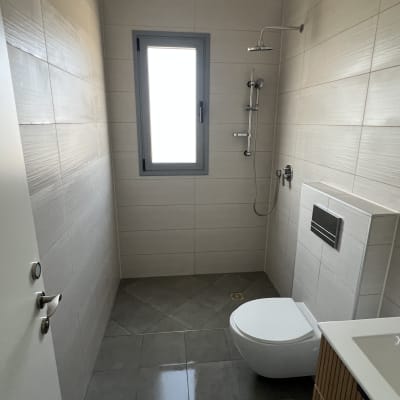 חדר אמבטיה נקי עם מקלחת ושירותים