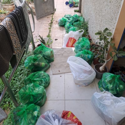 שקיות ירוקות ולבנות עם מוצרים בחצר