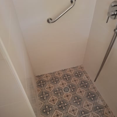 מקלחת עם אריחים מעוצבים, מוט אחיזה וברז חדש