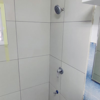 מקלחת עם אריחים חדשים וראש מקלחת מותקן