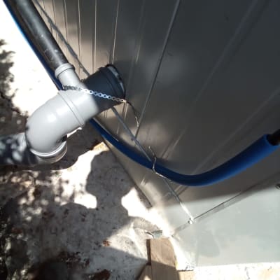 צינור מים דולף מחובר לקיר חיצוני