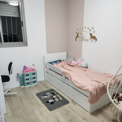 חדר ילדים עם מיטה, שטיח וצעצועים