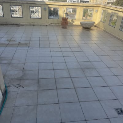 מרפסת מרוצפת עם עציצים, ללא אנשים או פעילות נראית לעין