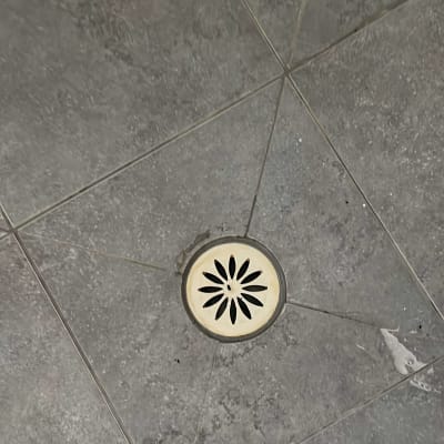 רצפת אריחים עם ניקוז עגול במרכז