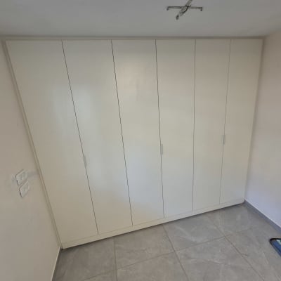ארון בגדים לבן בחדר עם שואב אבק
