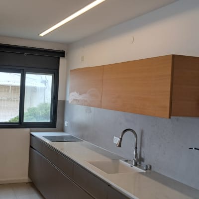 מטבח עם ארונות עץ, כיור וברז מתכת