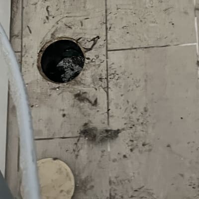 בור ניקוז פתוח עם מברג אדום על הרצפה