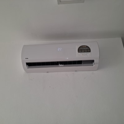 מזגן קיר לבן עם תצוגת טמפרטורה דיגיטלית