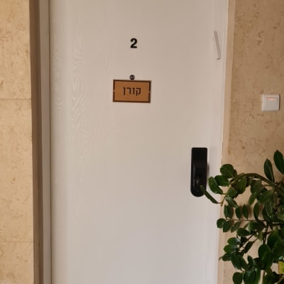 דלת לבנה עם ידית שחורה ושלט מספר 2