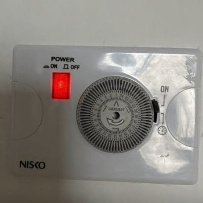 מתג חשמלי עם שעון טיימר על קיר לבן