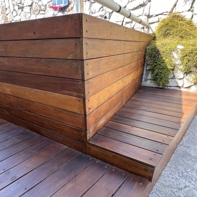 מבנה עץ עם דק ליד קיר אבן