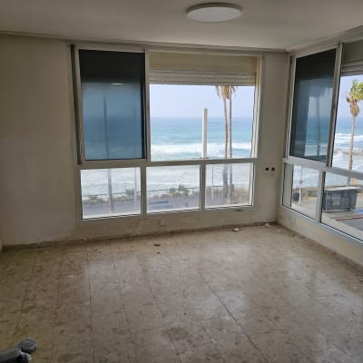 חדר ריק עם חלונות גדולים ונוף לים