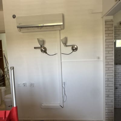 קיר עם מזגן ומנורות, דלי ומגב