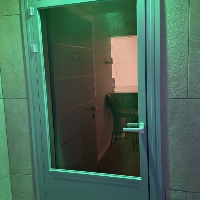 דלת אלומיניום עם ידית לבנה ותאורה ירוקה