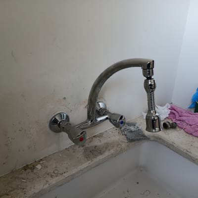 ברז מים מותקן על קיר עם כיור