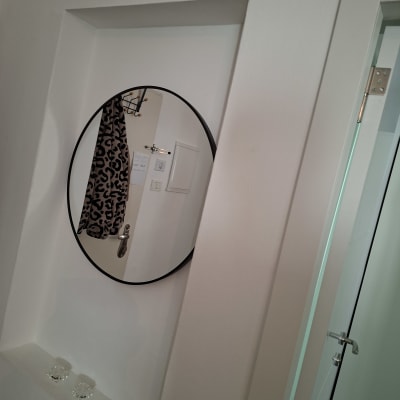 מראה עגולה על קיר עם מגבת מנומרת