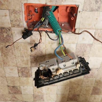 שקע חשמלי פגום עם חוטים חשופים וקופסה פתוחה