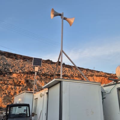 Loudspeakers on a pole with solar panel nearby