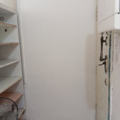 קיר לבן עם מדפים ודלת, מתאים לצביעה