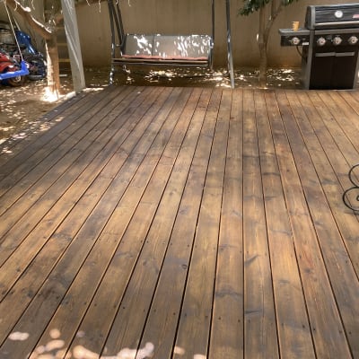 דק עץ בגינה עם גריל ונדנדה