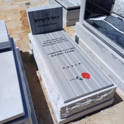 מצבה עם כיתוב בעברית ופרח אדום