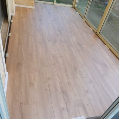 רצפת פרקט חדשה בחדר סגור עם חלונות זכוכית