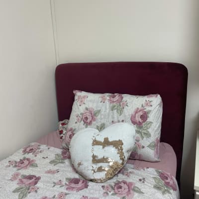 מיטה עם מצעים פרחוניים וכרית לב