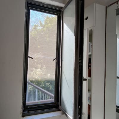 חלון אלומיניום פתוח עם מסגרת כהה