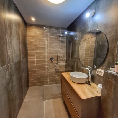 מקלחת עם ראש גשם וקירות אריחים חומים