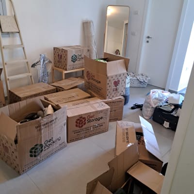 קופסאות קרטון לאריזה, סולם ומראה בחדר.