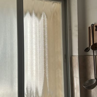 חלון זכוכית מט במטבח עם כלים תלויים