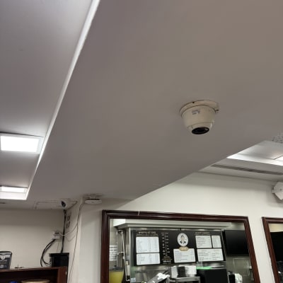 תקרה צבועה בלבן עם מצלמת אבטחה מותקנת