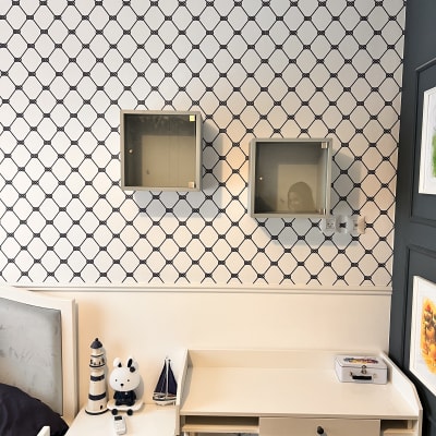 שני ארונות תלויים על קיר עם טפט מעוינים