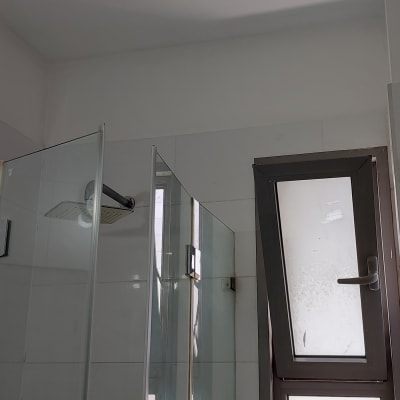 מקלחת עם דלת זכוכית וחלון פתוח