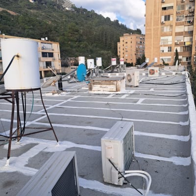 איטום גג עם חומר לבן בין יחידות מיזוג אוויר
