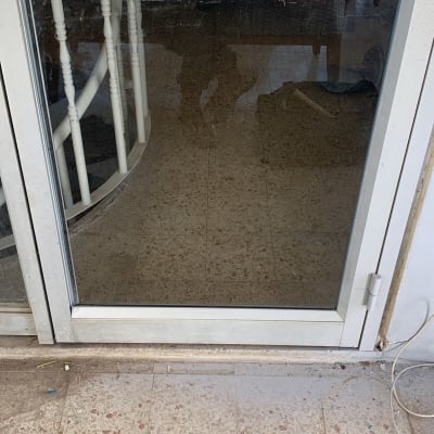 דלת זכוכית עם מסגרת מתכת ולכלוך על הזכוכית