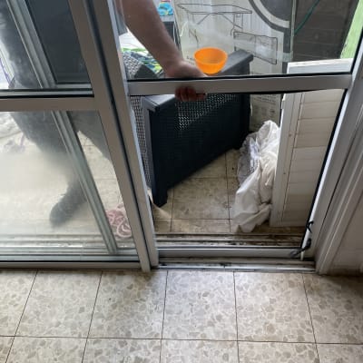 דלת זכוכית עם ידית, כוס כתומה על הרצפה