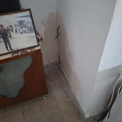 קיר עם תיקון טיח וחוטי חשמל חשופים