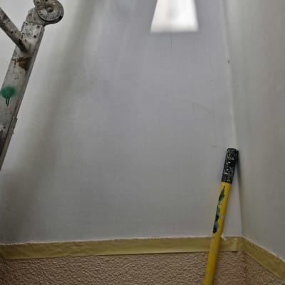 סולם מתכת ומוט צהוב צבועים בצבע על קיר לבן