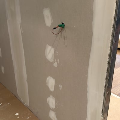 חוטי חשמל ירוקים יוצאים מקיר גבס