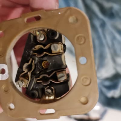 חלק חשמלי עם חיבורים וברגים ביד חשמלאי