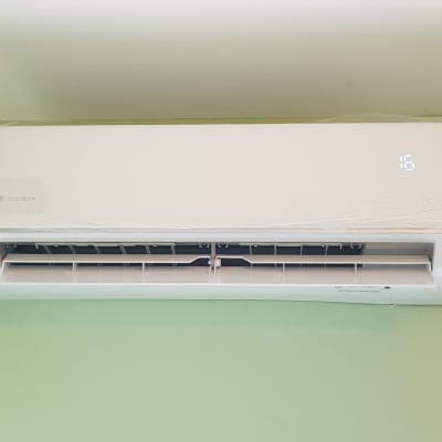 מזגן קיר לבן מותקן על קיר ירוק